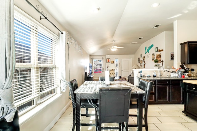 tiled dining space featuring sink, vaulted ceiling, ceiling fan, and plenty of natural light