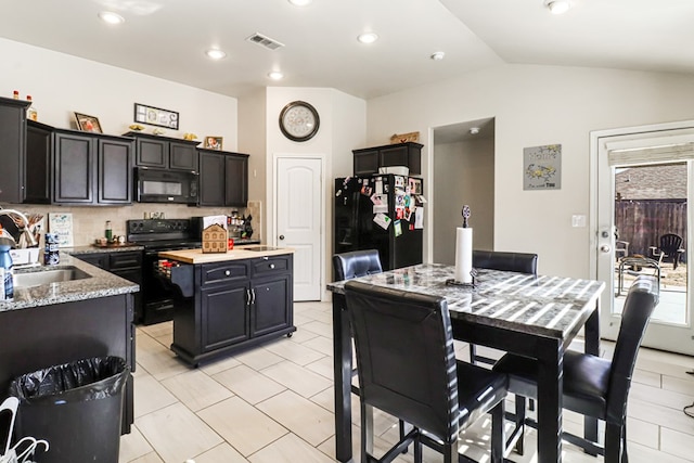 kitchen with lofted ceiling, sink, backsplash, a center island, and black appliances