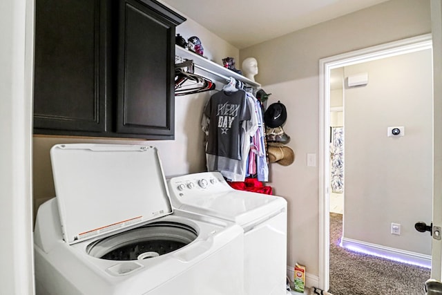 clothes washing area featuring cabinets, carpet floors, and washer and dryer