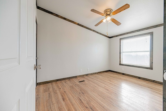 empty room with a textured ceiling, ceiling fan, and light hardwood / wood-style floors