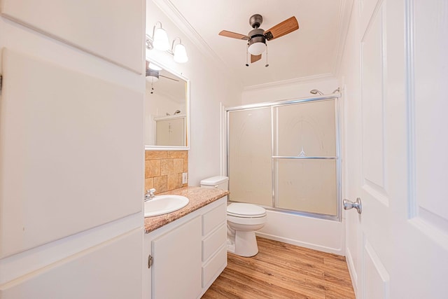 full bathroom featuring toilet, vanity, combined bath / shower with glass door, wood-type flooring, and crown molding