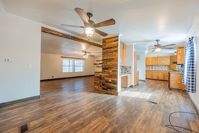 unfurnished living room featuring a textured ceiling, ceiling fan, dark hardwood / wood-style flooring, and crown molding