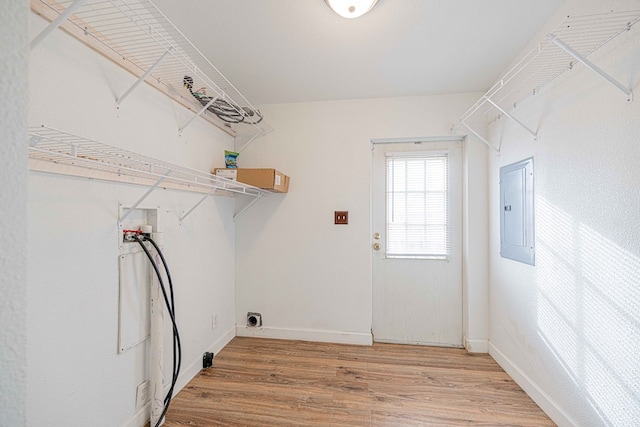 washroom with electric panel, hardwood / wood-style floors, and hookup for a washing machine