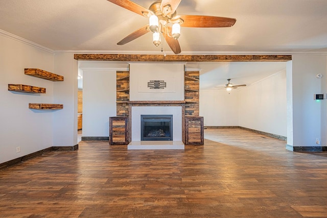 unfurnished living room with ceiling fan, a large fireplace, dark hardwood / wood-style flooring, and crown molding