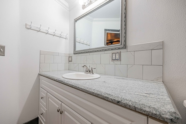 bathroom featuring vanity, backsplash, and crown molding