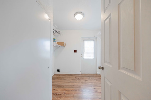 laundry area with a textured ceiling and light hardwood / wood-style flooring