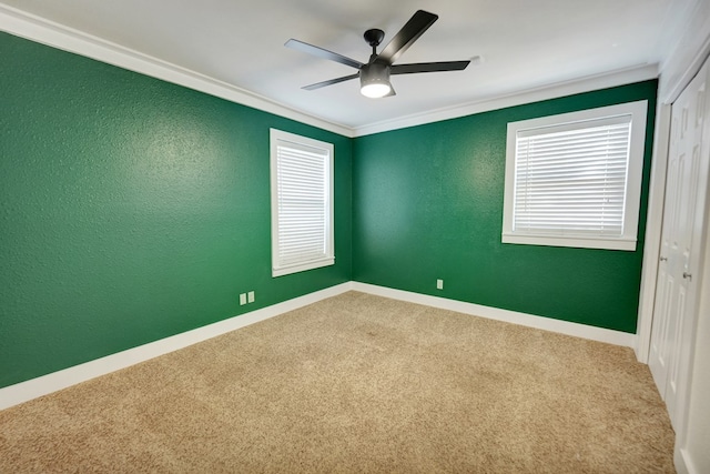 spare room with crown molding, carpet, and ceiling fan