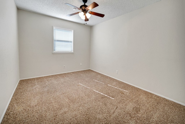 empty room with ceiling fan, carpet flooring, and a textured ceiling