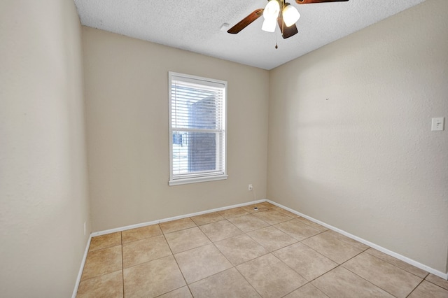 unfurnished room featuring ceiling fan, light tile patterned floors, and a textured ceiling