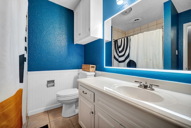 bathroom with vanity, tile patterned floors, a textured ceiling, and toilet