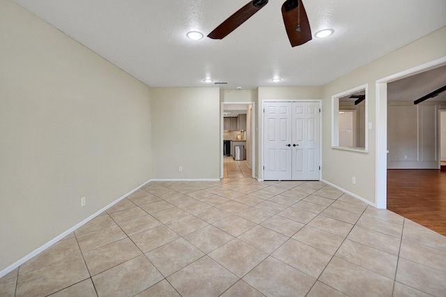 unfurnished bedroom with ceiling fan, a textured ceiling, a closet, and light tile patterned floors