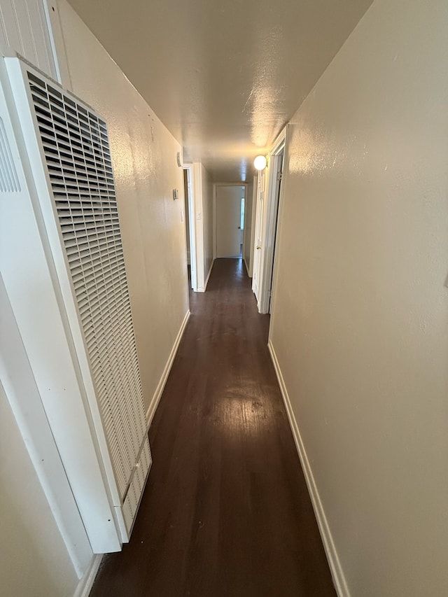 hall featuring a textured ceiling and dark hardwood / wood-style floors