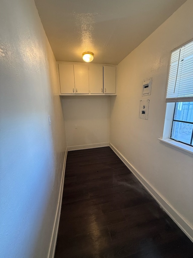 laundry area with a textured ceiling and dark hardwood / wood-style flooring