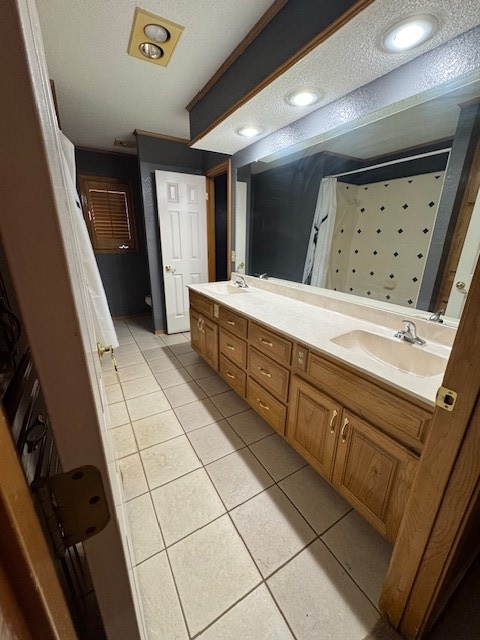 bathroom featuring tile patterned flooring, a textured ceiling, and vanity