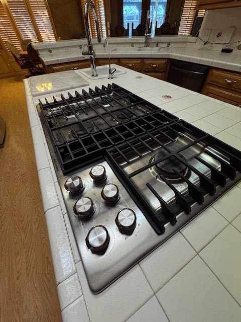 details with dishwasher, decorative backsplash, and tile countertops