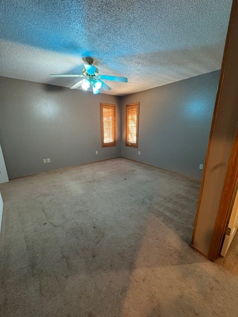 carpeted spare room with ceiling fan and a textured ceiling