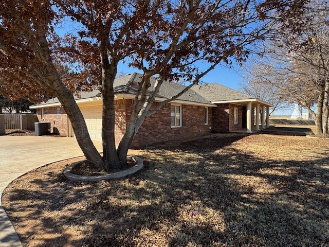 view of property exterior with central air condition unit and a garage