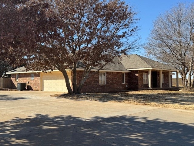 single story home with a garage and cooling unit