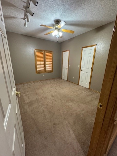 unfurnished bedroom with ceiling fan and light colored carpet