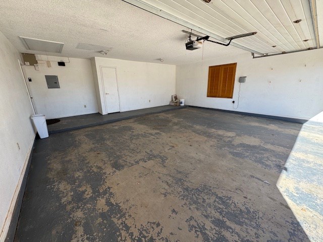 garage with electric panel and a garage door opener