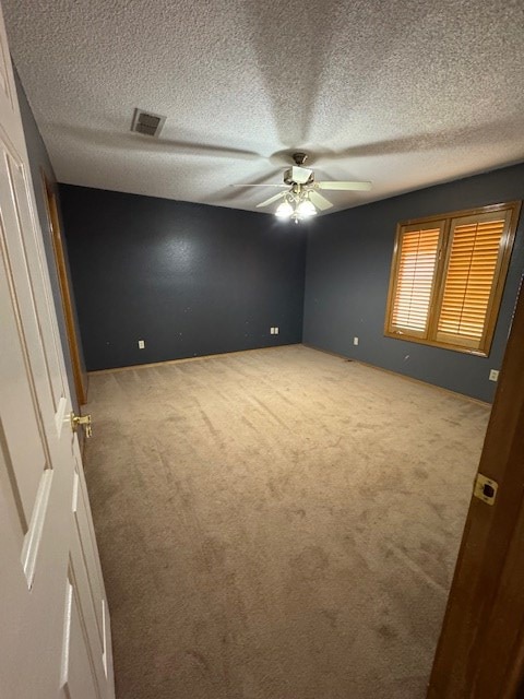 unfurnished bedroom with a textured ceiling, carpet floors, and ceiling fan