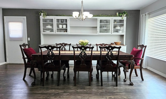 dining area with an inviting chandelier and dark wood-type flooring