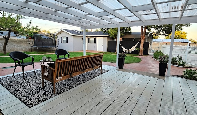 deck with a lawn, outdoor lounge area, a trampoline, a pergola, and a patio area