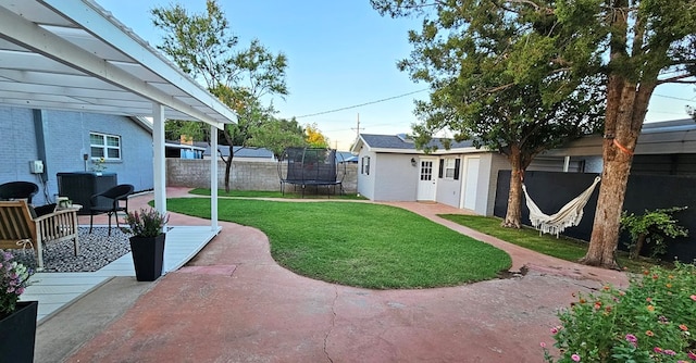 view of yard with an outbuilding, a patio, a trampoline, and central air condition unit