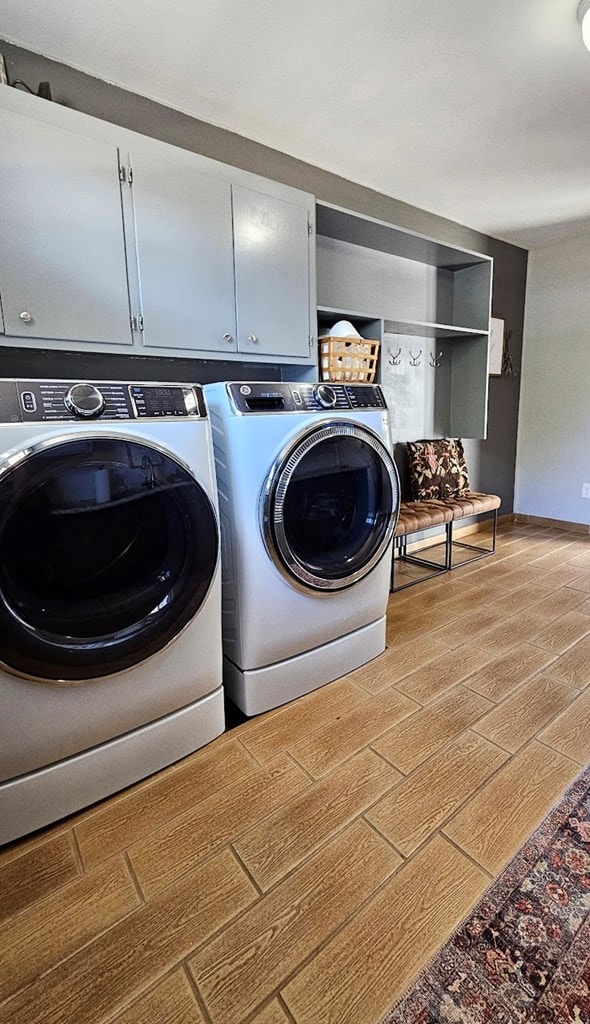 laundry room with cabinets, separate washer and dryer, and light hardwood / wood-style flooring