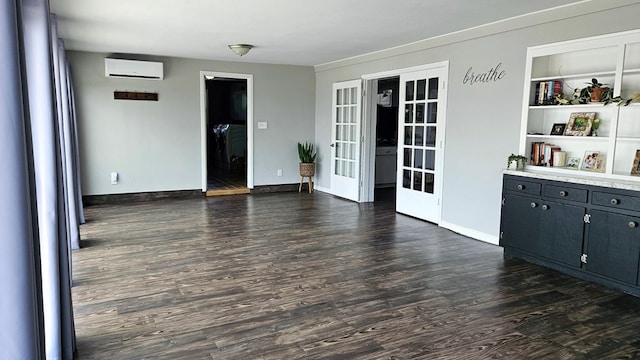 interior space featuring built in shelves, dark wood-type flooring, a wall unit AC, and french doors