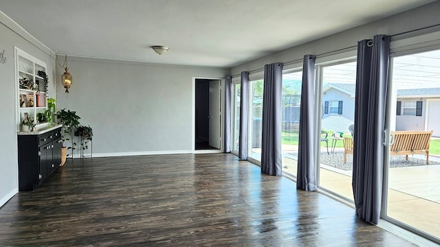 empty room with built in features and dark wood-type flooring