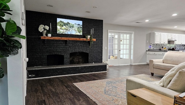 living room featuring dark hardwood / wood-style flooring and a fireplace