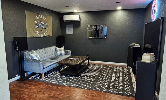 living room with dark hardwood / wood-style floors, a textured ceiling, and a wall unit AC