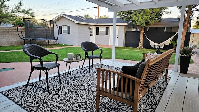 view of patio featuring a wooden deck and a trampoline