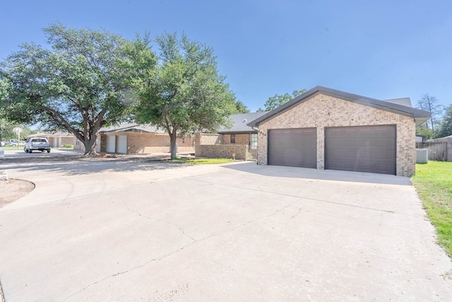 ranch-style house featuring cooling unit and a garage