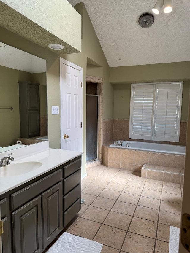 bathroom with tile patterned flooring, vanity, independent shower and bath, a textured ceiling, and lofted ceiling