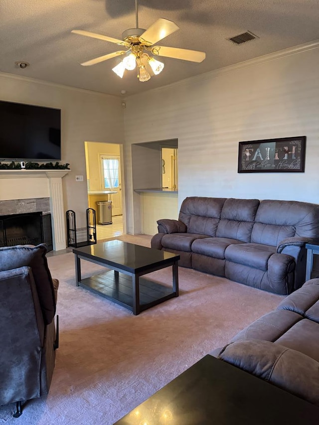 living room with a textured ceiling, ceiling fan, crown molding, and carpet flooring