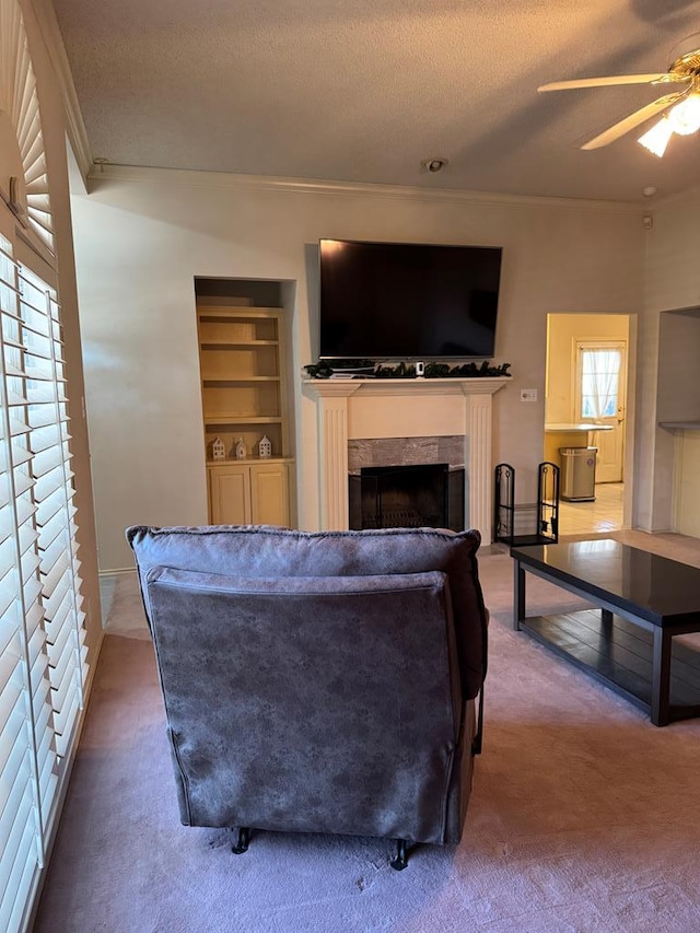 carpeted living room with a tile fireplace, ceiling fan, and a textured ceiling