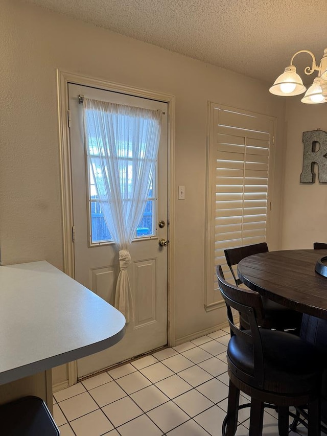 tiled dining area with a textured ceiling