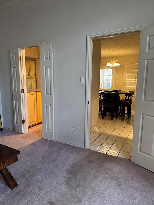 spare room featuring a notable chandelier and light colored carpet