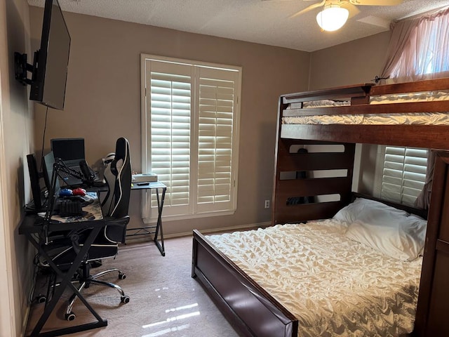 bedroom with a textured ceiling, ceiling fan, and light colored carpet