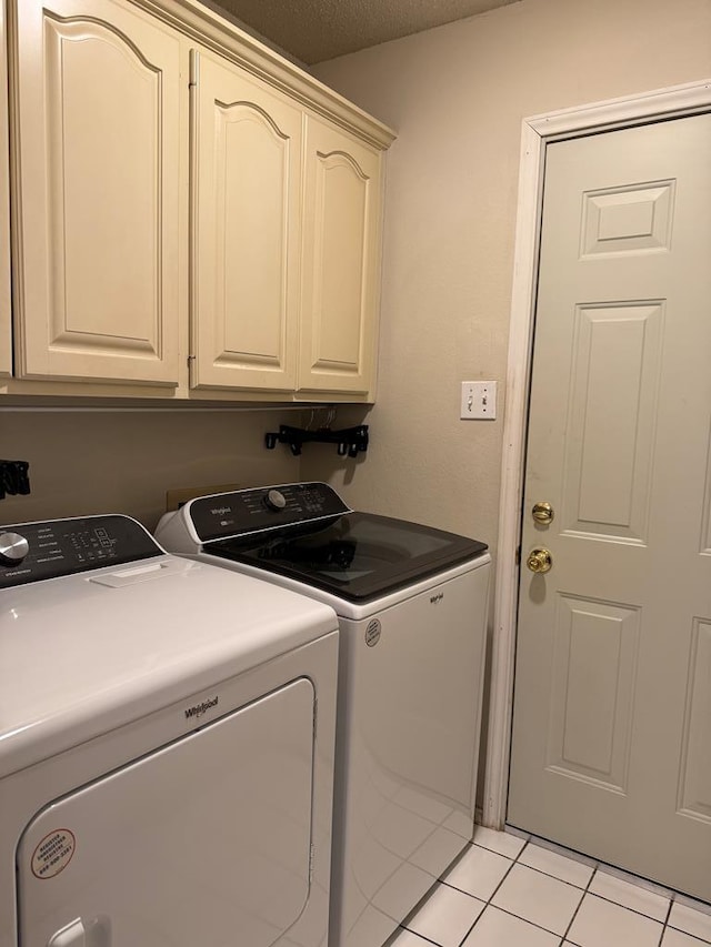 clothes washing area featuring independent washer and dryer, cabinets, and light tile patterned floors