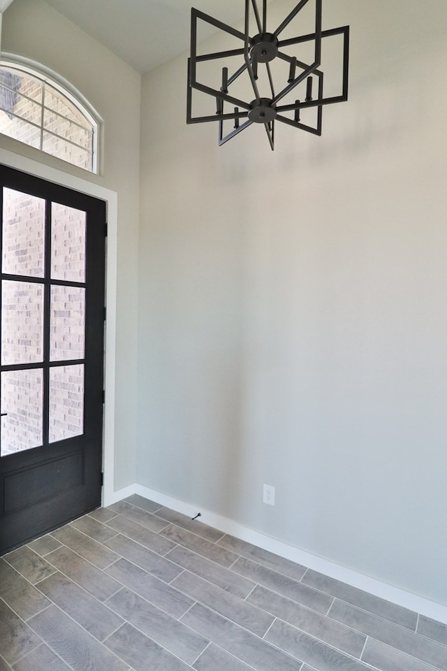 foyer featuring a notable chandelier and baseboards