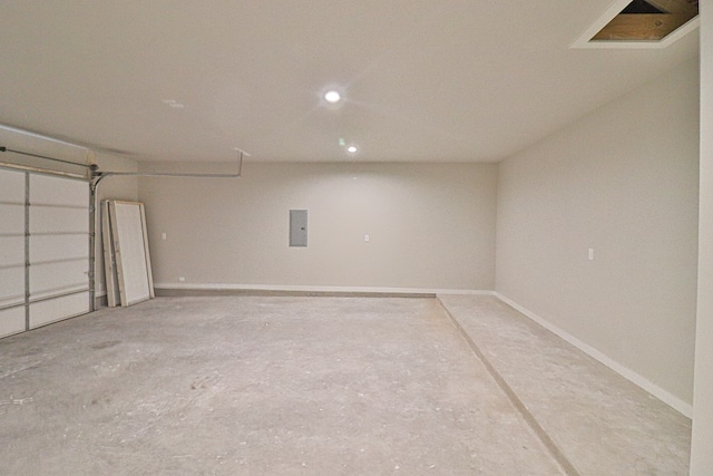 garage featuring visible vents, electric panel, and baseboards