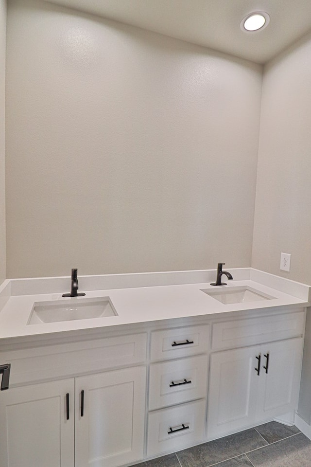 full bath with double vanity, a sink, and recessed lighting