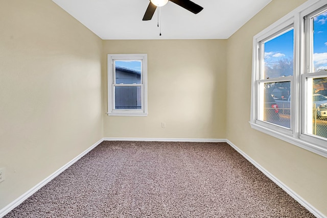 spare room featuring carpet floors, a ceiling fan, and baseboards