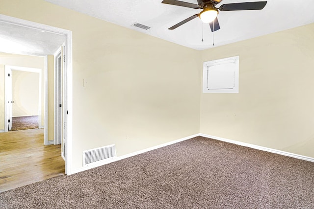 empty room featuring carpet, visible vents, and baseboards