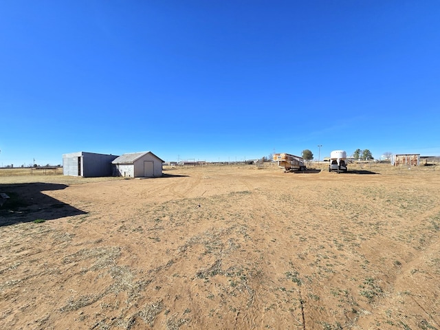 view of yard with a storage unit and a rural view