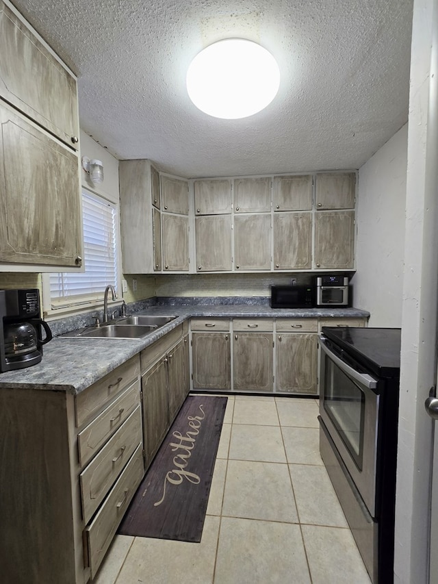 kitchen featuring light tile patterned flooring, sink, stainless steel range with electric cooktop, and a textured ceiling