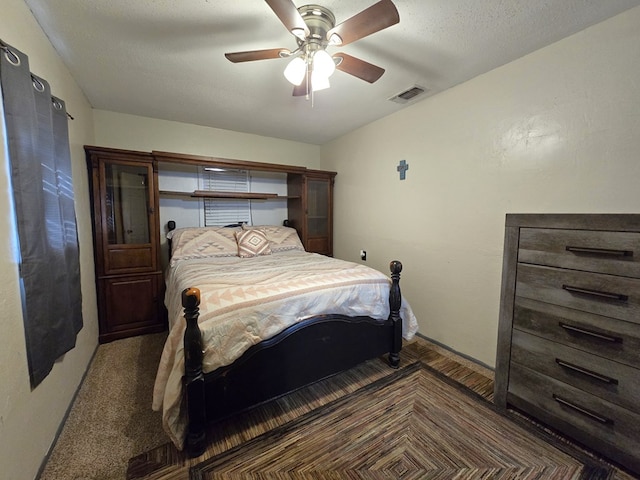 bedroom with ceiling fan and dark colored carpet